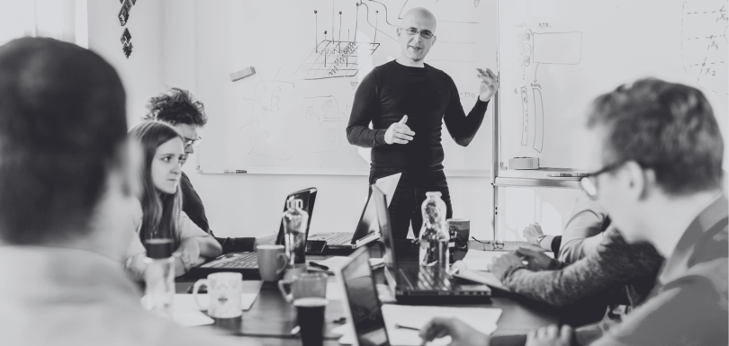 Varias personas en una reunión de equipo hablando sobre el cambio cultural interno de la empresa