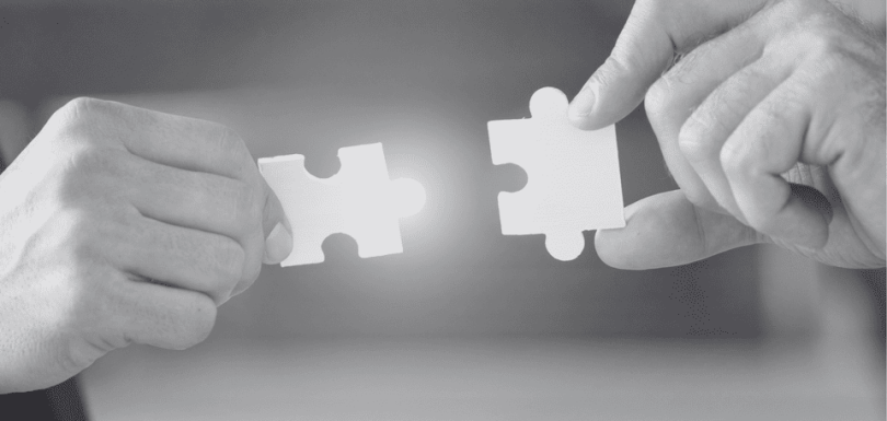 Dos manitas sujetando unas piezas de puzle representando la unión de plataformas empresariales