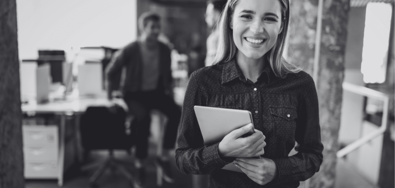 propósito-estratégico. Una mujer sujetando una carpeta en un ambiente laboral de oficina